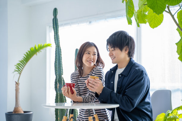 年轻的微笑交谈夫妇喝咖啡在明亮的客厅图片下载