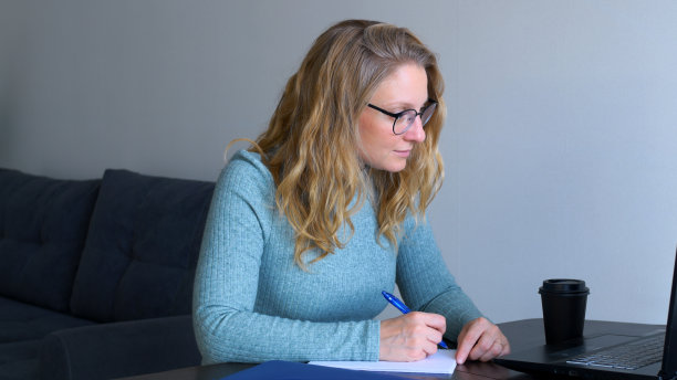 女导师在笔记本电脑前与学生在线学习。这位女士主持了一门在线课程，教授她的课程，并认真听取学生对课程主题问题的回答，并点头。图片下载