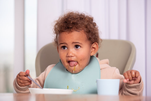 正在用餐盘里吃东西的女宝宝图片下载