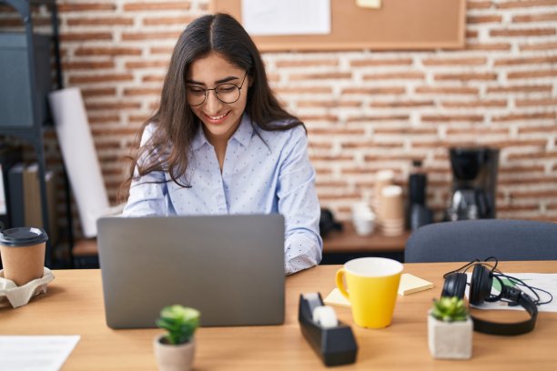 年轻的西班牙女孩业务工作者使用笔记本电脑在办公室工作图片下载