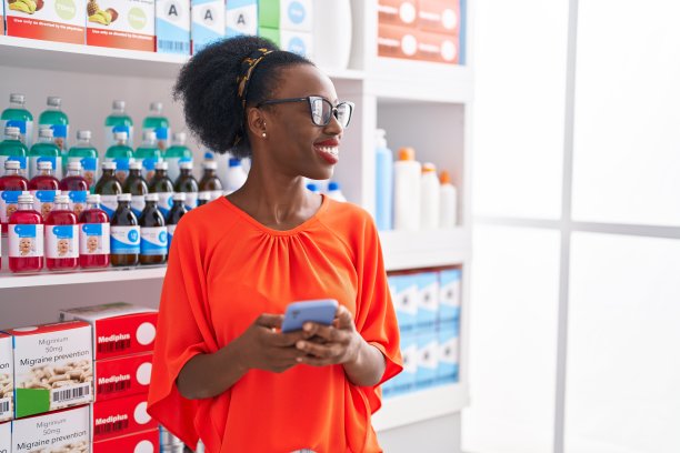 非裔美国女顾客在药店用智能手机自信地微笑图片下载