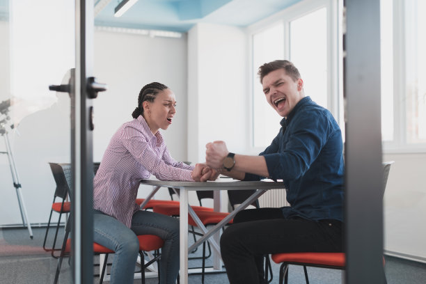 商人，竞争和人的概念-在现代明亮的开放空间联合办公的创业公司办公室，女商人和商人在公司会议期间掰手腕。图片下载