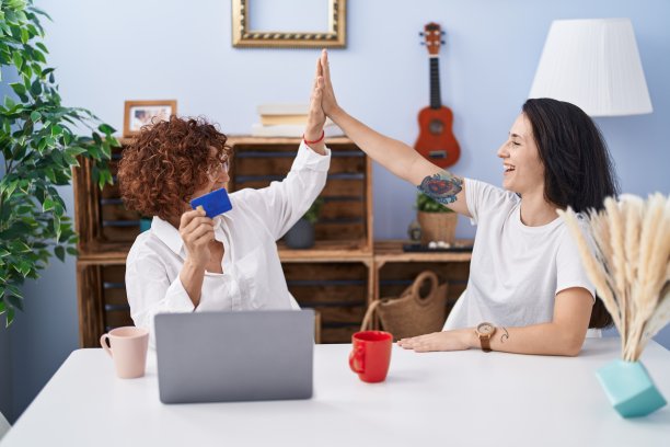 两名女性母女在家里使用笔记本电脑和信用卡图片下载