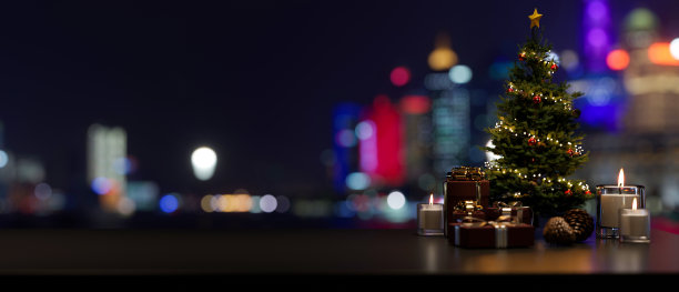 在桌子上复制空间，圣诞树和装饰靠窗，城市夜景灯光图片下载