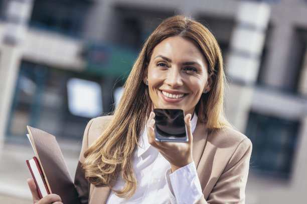 公司女性用智能手机记录语音信息，用手机对着麦克风说话。图片下载
