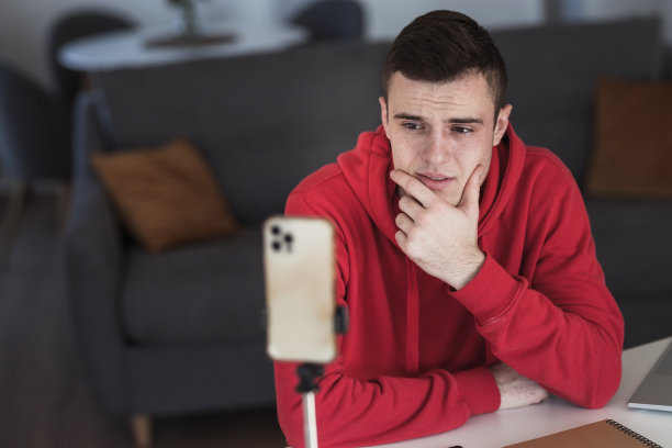 严肃的男性网红正在看智能手机图片下载