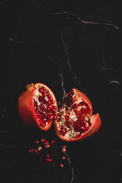 垂直镜头的一个分裂的石榴在黑色背景图片下载