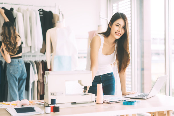 美丽的年轻成年亚洲女性设计师眼睛看相机站在工作室背景的肖像图片下载