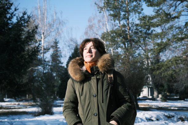 成熟的女人走在冬天的公园里图片下载