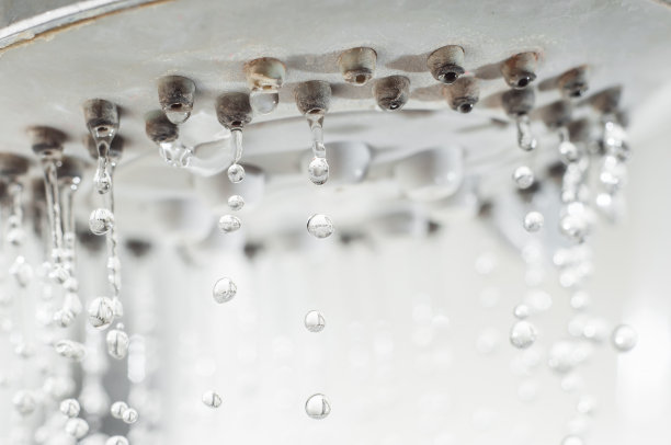 水滴从淋浴龙头上滴下来。图片下载