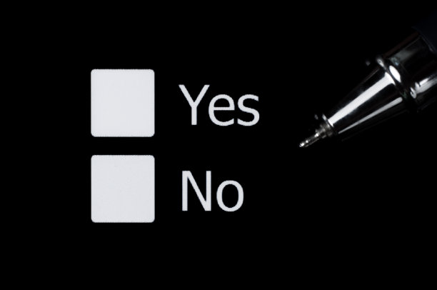 是和否之间的选择。用钢笔在黑色背景的白色方块上打勾。投票。图片下载