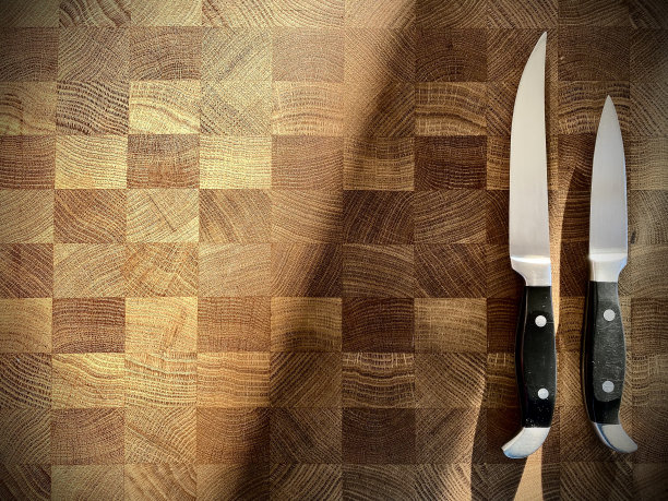 不锈钢厨刀在橡木砧板上的特写图片下载