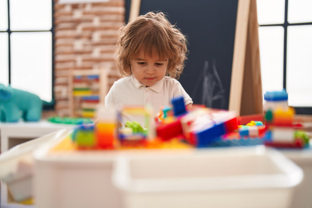 可爱的西班牙幼儿站在幼儿园玩积木图片下载