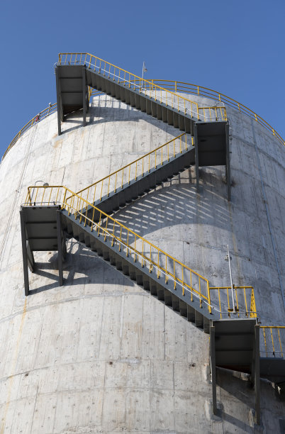 金属楼梯，混凝土墙上的黄色栏杆图片下载