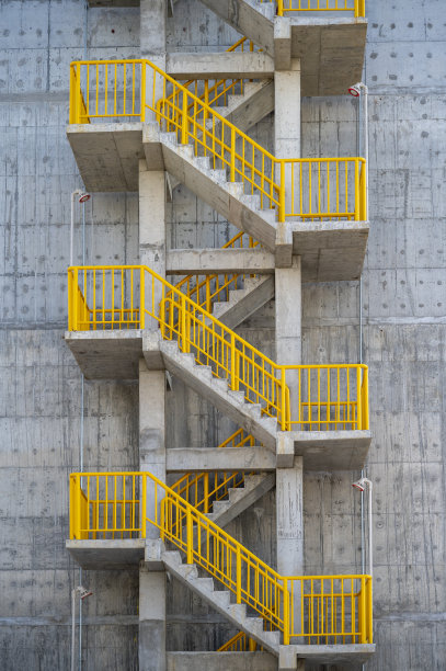 金属楼梯，混凝土墙上的黄色栏杆图片下载