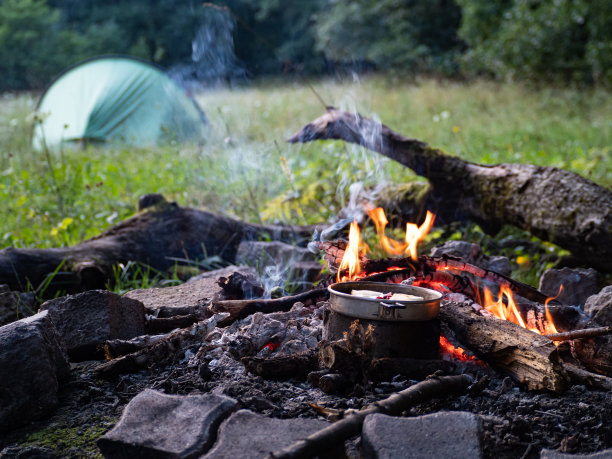 在篝火上做饭，背景是帐篷图片下载