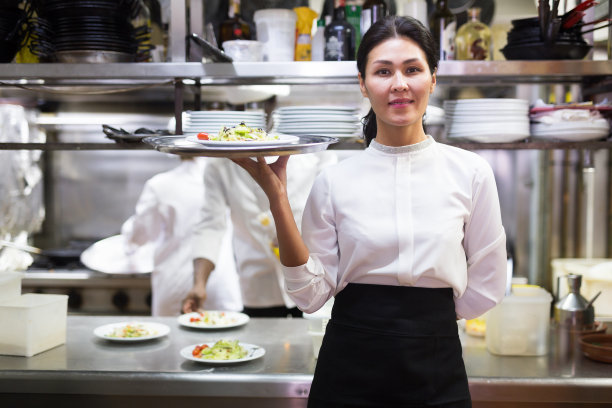 快乐的女服务员站在白色厨房在咖啡馆的肖像图片下载