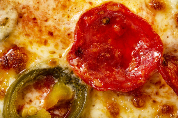 一个披萨的近景。宏观照片。意大利辣香肠香肠披萨配墨西哥胡椒。图片下载