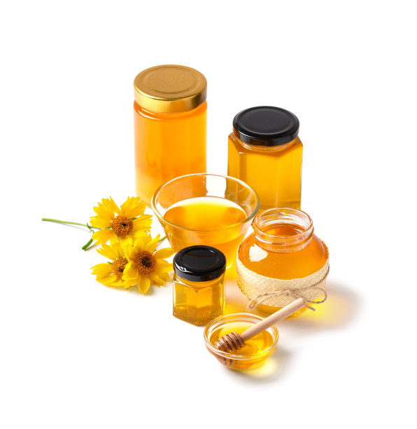 蜂蜜在玻璃罐里，黄色的花朵在白色的背景上图片下载