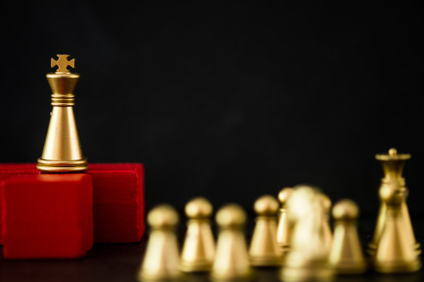 金色的国王象棋站在红色的木架上，比他们的任何象棋都要高。老板和领导的概念图片下载