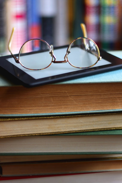 一堆书，电子阅读器和眼镜图片下载