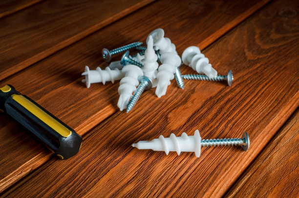 螺丝与塑料喷嘴和工具在棕色木制复古背景图片下载