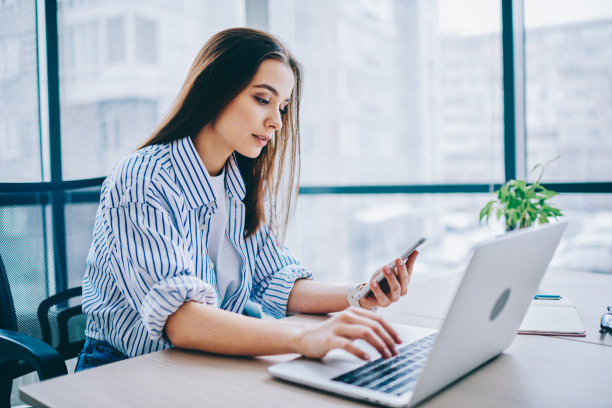 千禧一代女性培训生在IT专业人士的现代办公室试用工作日检查现代智能手机小工具的时间，白人女性连接蓝牙共享多媒体图片下载