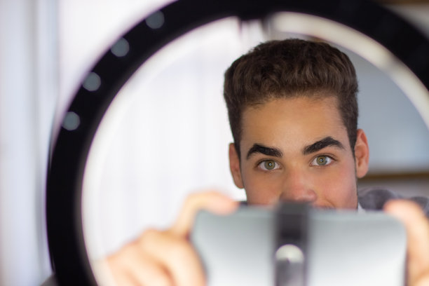 一个年轻人准备录制他的视频博客的特写图片下载