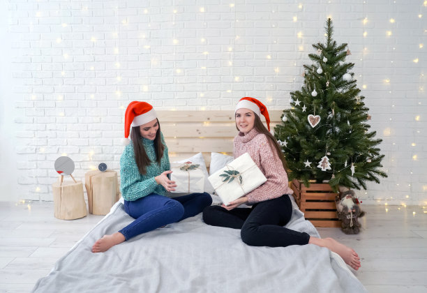 妇女们在圣诞树旁交换圣诞礼物图片下载