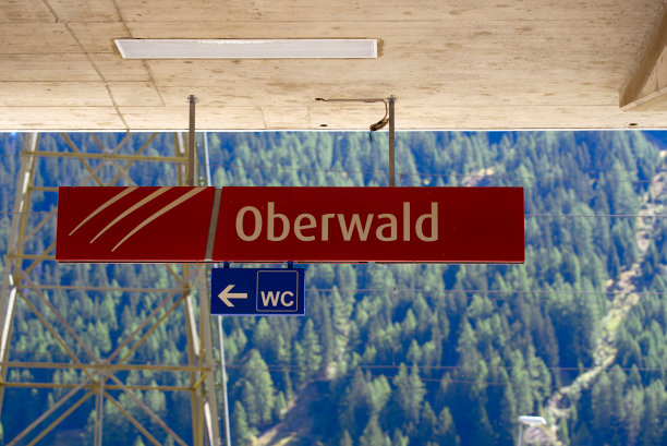 在阳光明媚的夏末一天，瓦莱州奥伯瓦尔德山村的火车站和汽车穿梭列车终点站的红色标志。图片下载