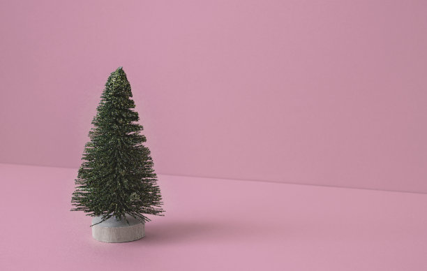 圣诞树简单的背景材料。粉色背景上的圣诞树。图片下载