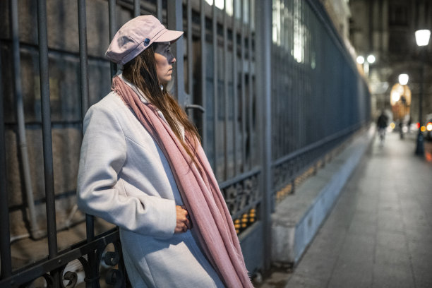 晚上在城里等朋友的女人。城市打破。图片下载