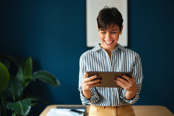 一个美丽的现代商业女性在她的办公室使用平板电脑的肖像图片下载