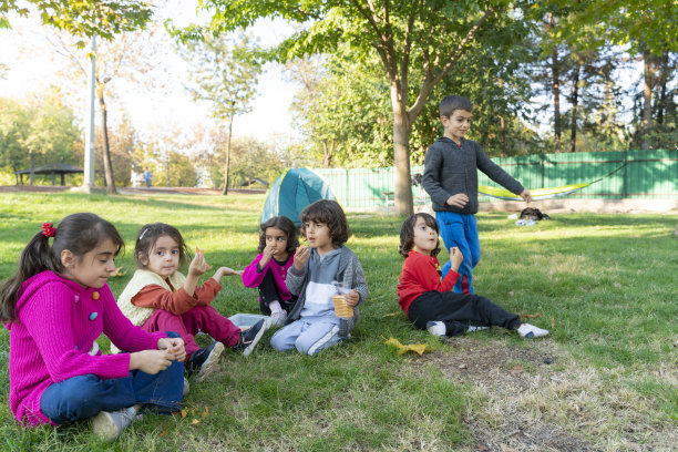 孩子们坐在草地上轮流讲故事，互相倾听图片下载