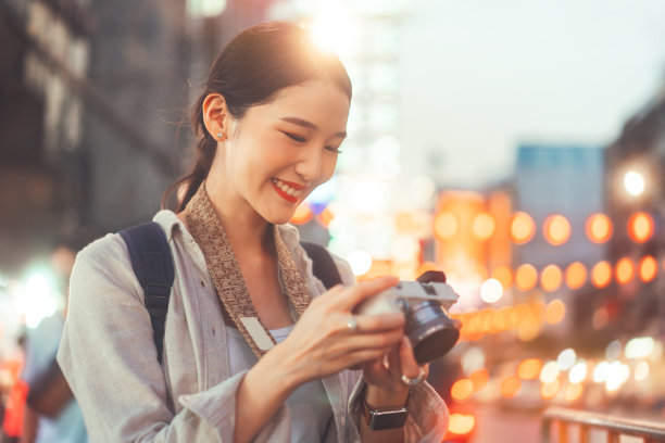 年轻的成年亚洲女子旅行者背包使用相机摄影在城市图片下载