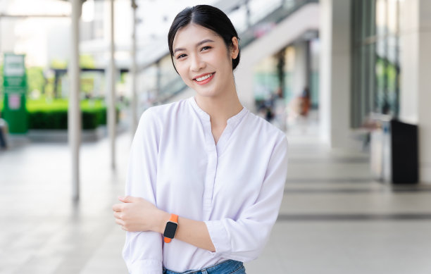 在街上快乐微笑的年轻女子图片下载