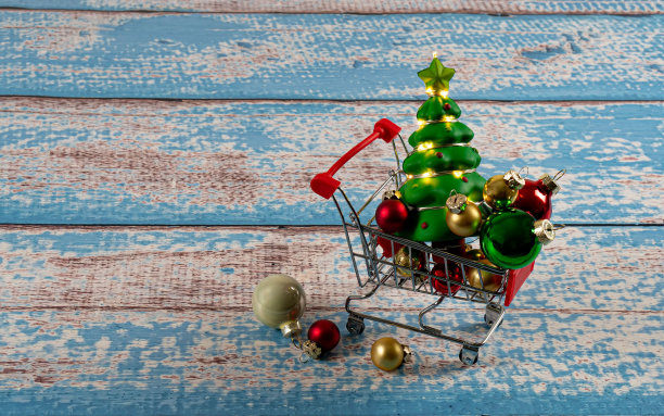 购物车里有圣诞球，蓝色的木板上有花环。图片下载