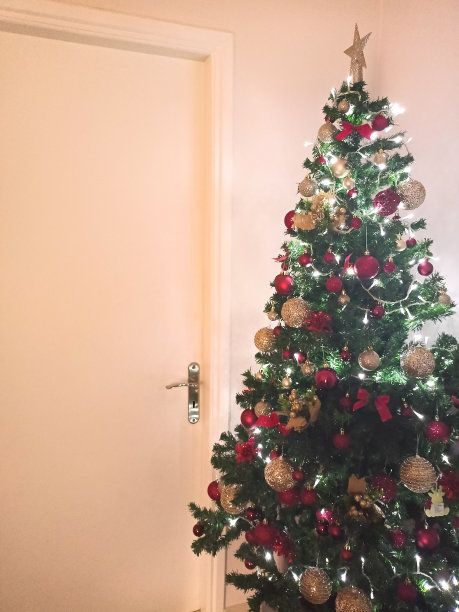 柔和的圣诞树背景与红色的金色装饰和可见的门图片下载