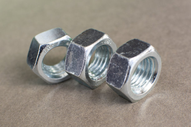 金属板螺母隔离在灰色背景上。镀铬螺母。钢螺母图片下载