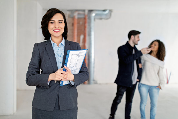 房地产经纪人向一对幸福的夫妇展示新公寓的肖像图片下载