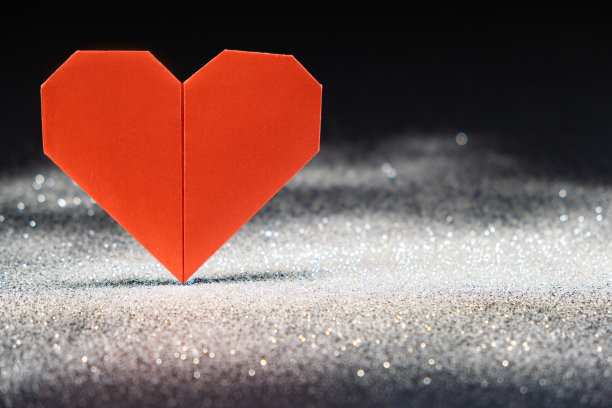 纸心，2023年的流行色品红万岁，黑色背景上有白色亮片的折纸图片下载