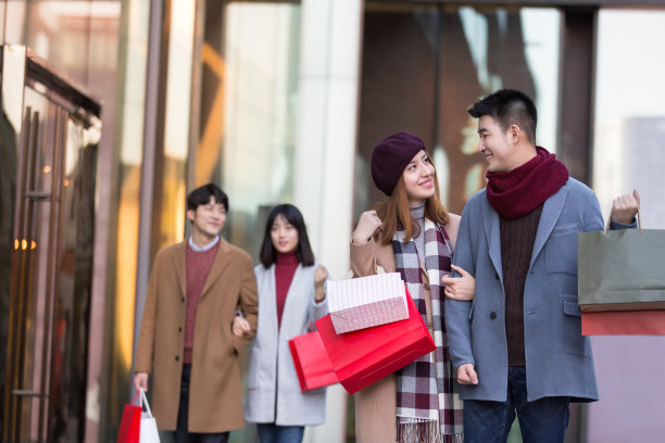 冬季情人节，年轻的东亚情侣在繁忙的户外购物街购物图片下载