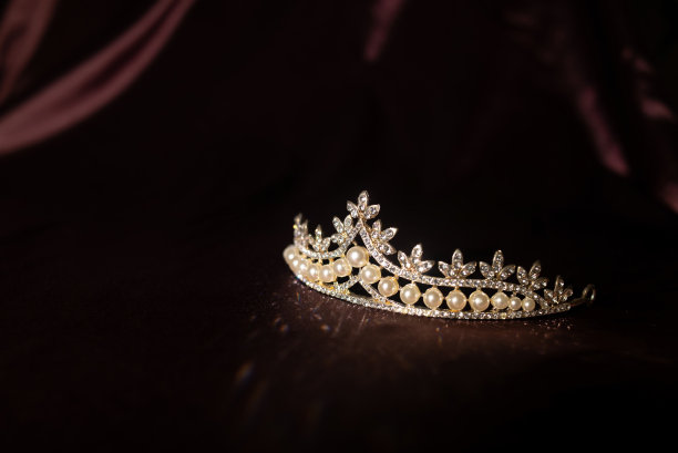 奢华的复古珍珠冠冕上暗红色缎面，丝绸背景图片下载
