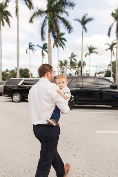 2022年12月，在南佛罗里达州，一位31岁的美国父亲和他10个月大的儿子穿着喜庆的红色圣诞服装拍摄家庭圣诞照片图片下载