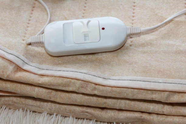 一个温暖的双面新电床单，组装在白色背景上。在寒冷的冬天，这是一种快速而经济的取暖方式图片下载