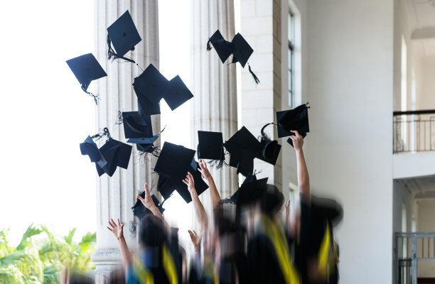 一群毕业生把毕业帽抛向空中图片下载
