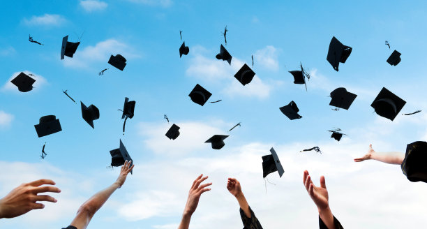 即将毕业的学生将毕业帽抛向空中图片下载