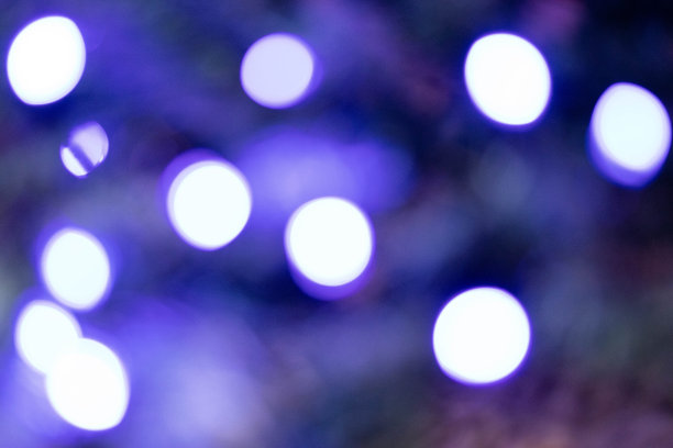 抽象的彩色散景在黑暗的背景。黑色背景上紫色散景的美丽背景图片下载