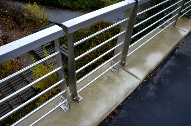 屋顶停车场混凝土墙上的不锈钢栏杆。把螺丝固定在阁楼的底部。金属片能排水。钢丝网防止儿童坠落图片下载