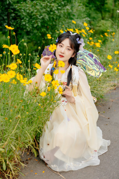 一个穿着中国服装的亚洲美女，正在室外花丛中图片下载